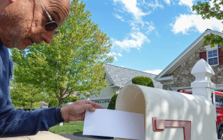 Brief wird in Briefkasten eingeworfen